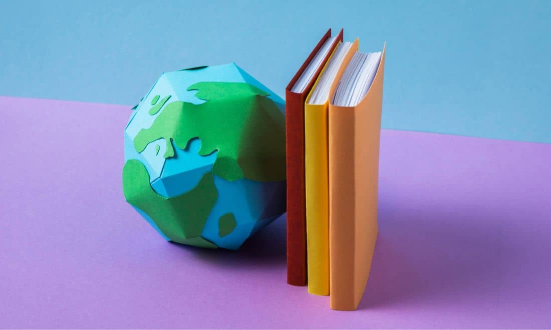 globo feito de papel e livros coloridos num tampo lilás