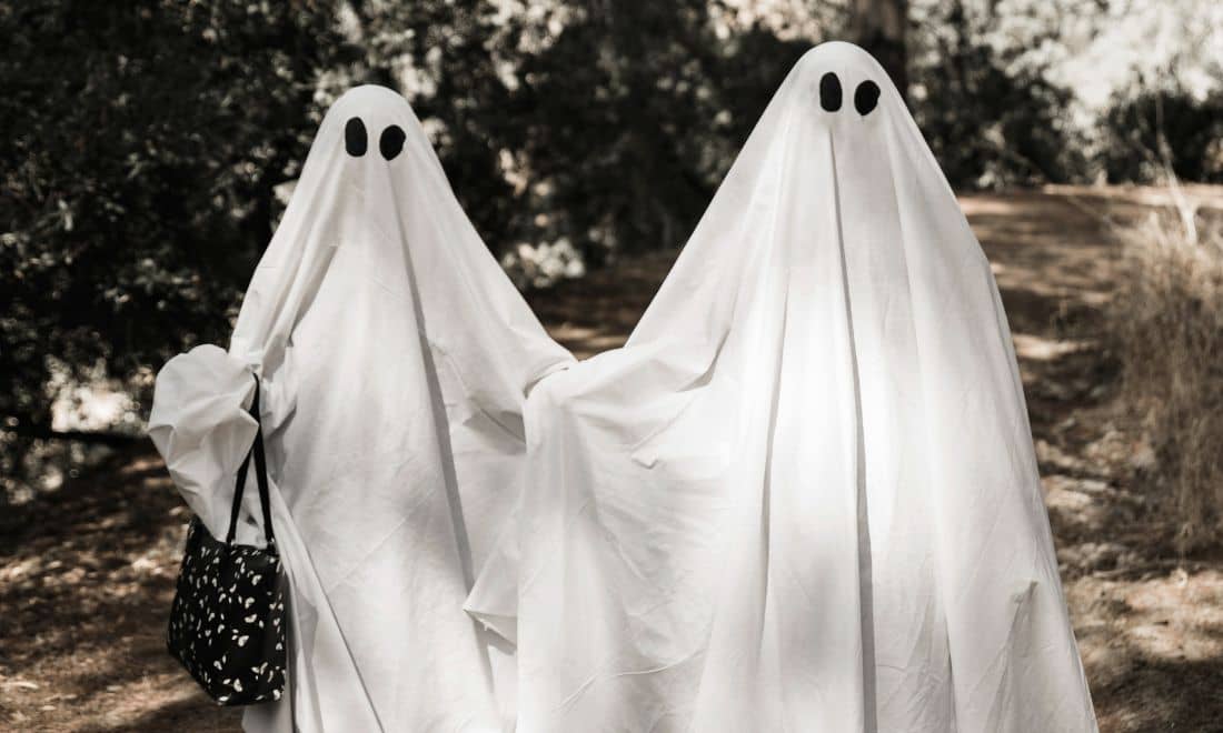 duas pessoas disfarçadas de fantasmas no halloween