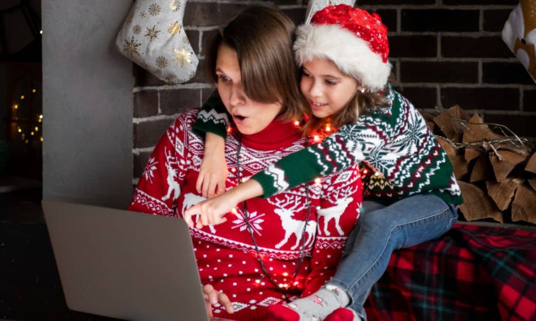mãe e filha vestidas com roupas de natal a comprar presentes online
