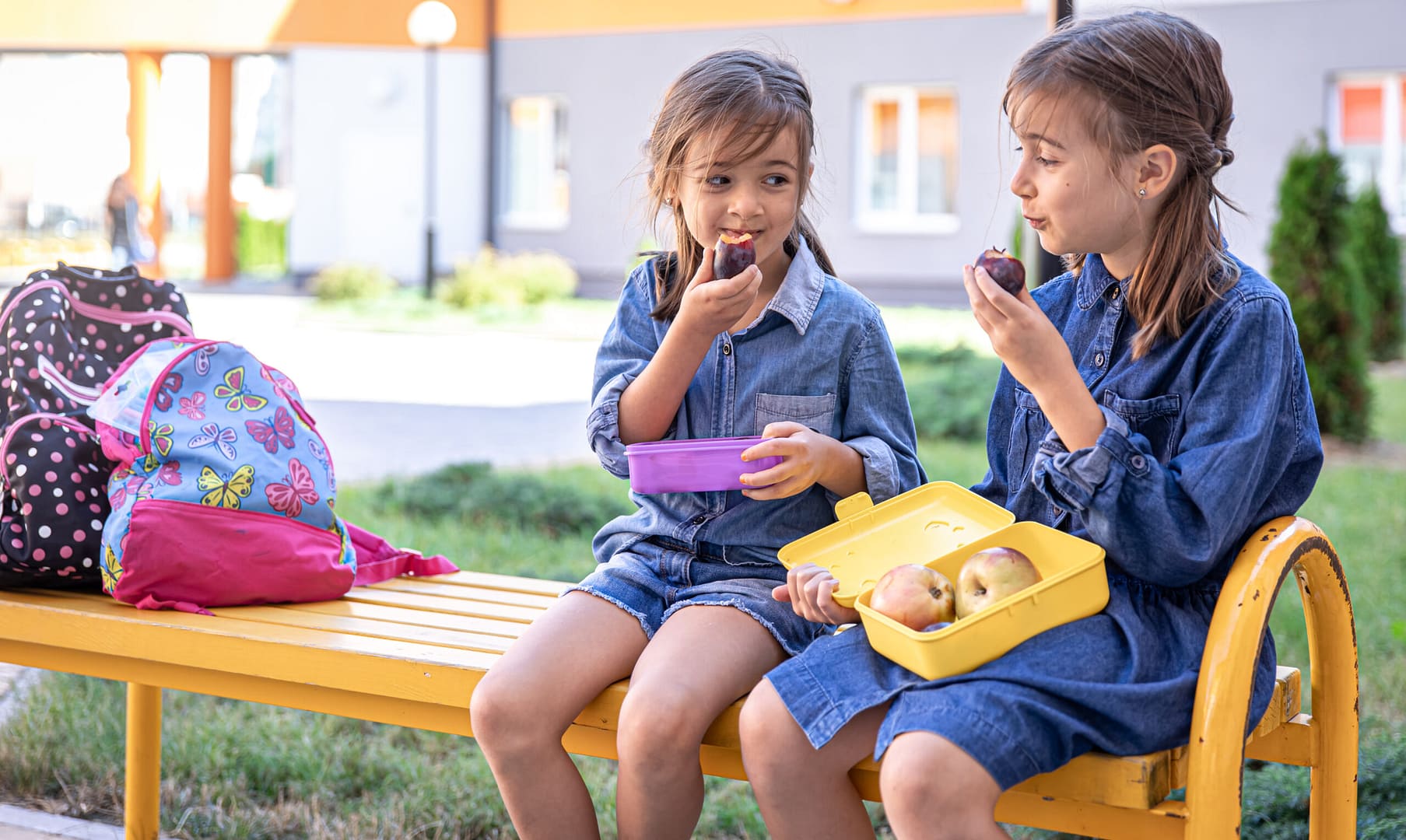 Meninas na escola sentada no banco do patio da escola a comer