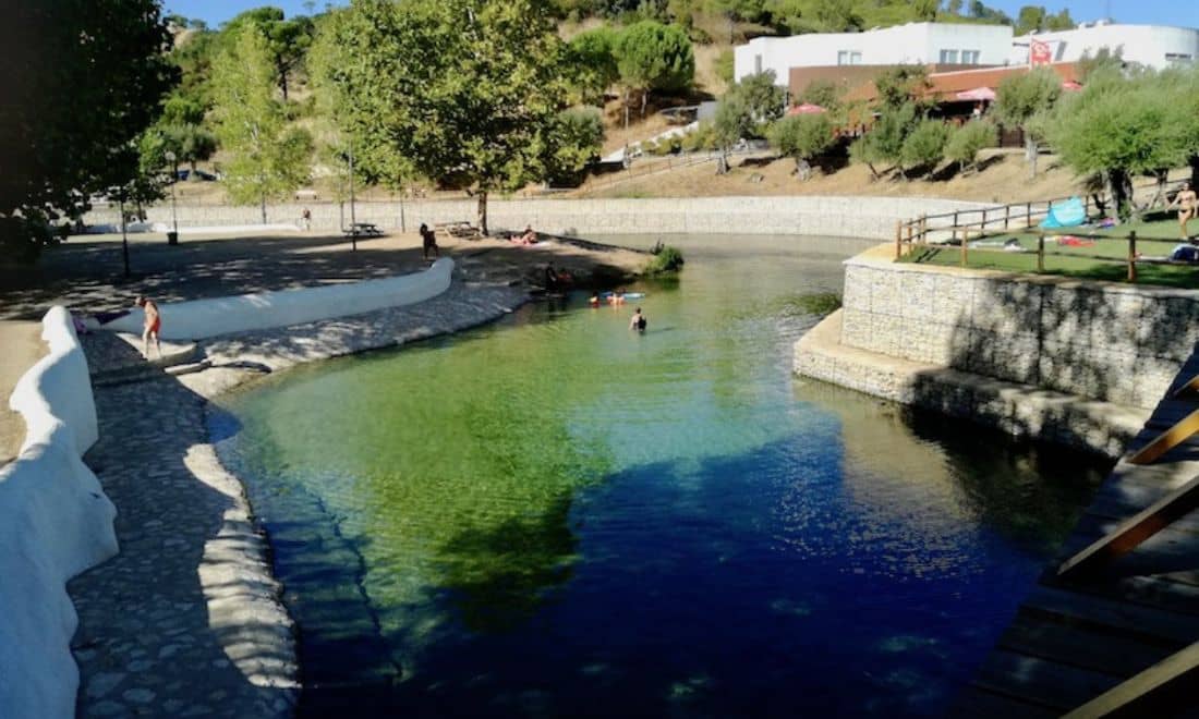 praia fluvial com água azul e com poucas pessoas