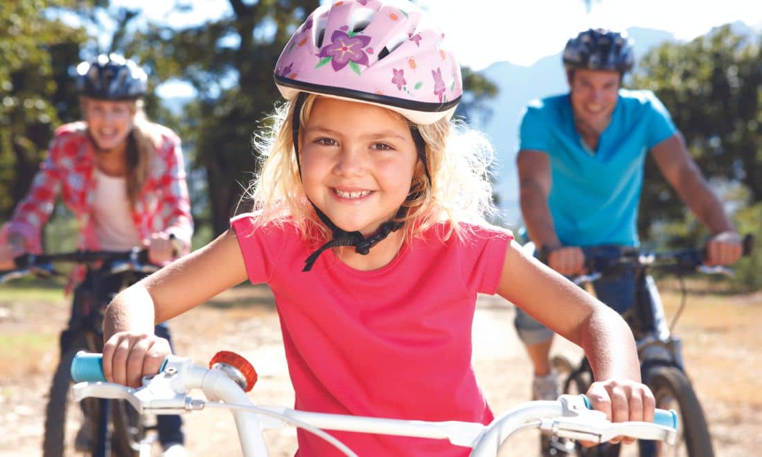 pai, mãe e filha em cima de bicicleta 