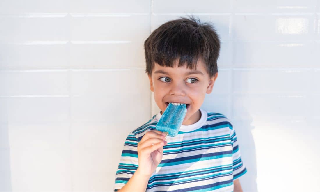 criança de olhos azuis a comer gelado azul