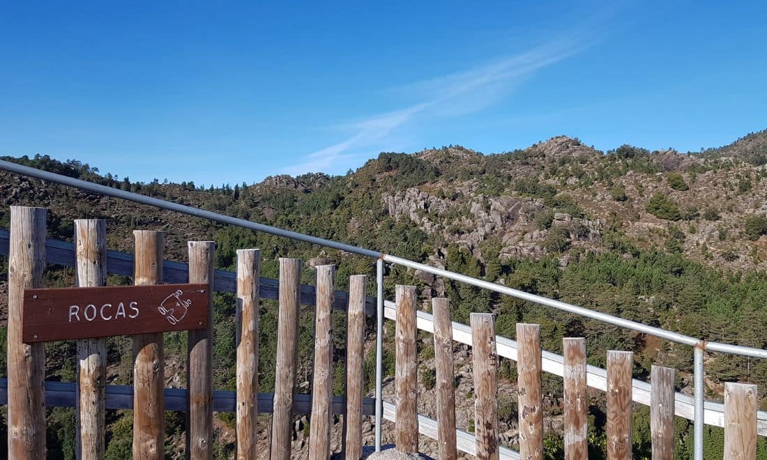 vista da serra e vedação de madeira com a sinalética do miradouro das rocas