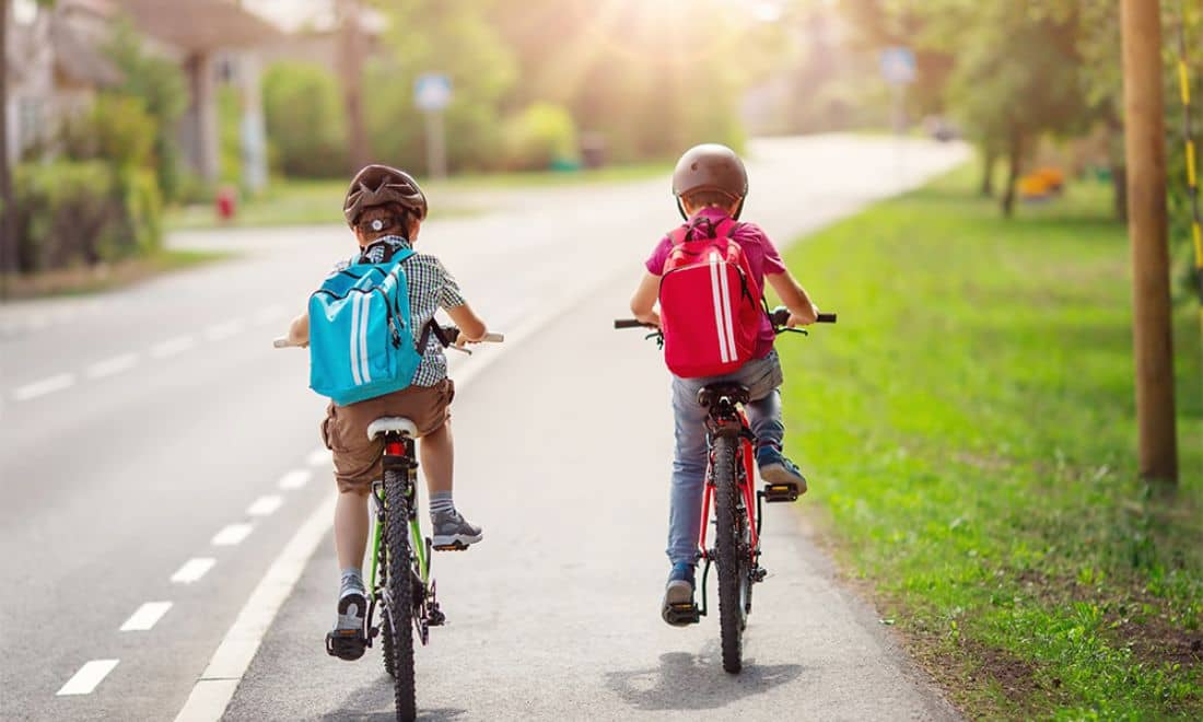 Emel segurança infantil duas crianças a andar de bicicleta para a escola na estrada