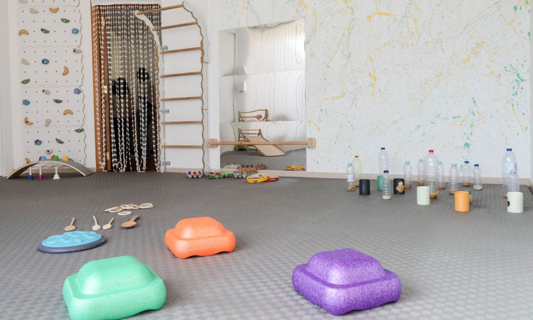 Salpicos desenvolvimento infantil espaço sala com garrafas de plástico, brinquedos, espaldar, escalada