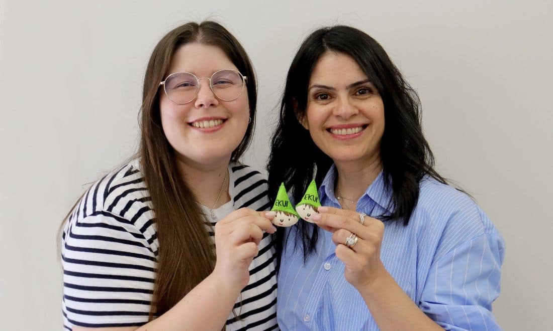 EKUI metodologia de ensino professora e aluna com boneco Ekui duende nas mãos