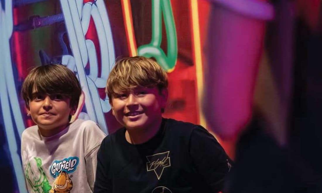 JumpYard dois meninos a sorrir luzes neon atrás