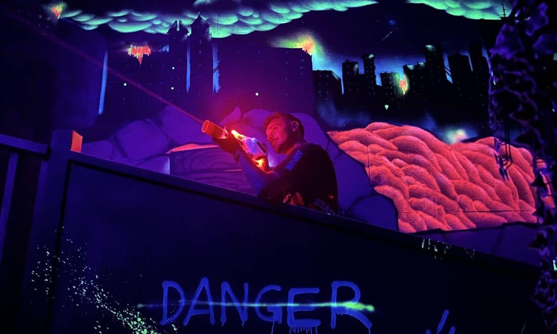 Quantum Park Laser Tag rapaz com pistola laser Danger Zone com ilustrações e luzes neon