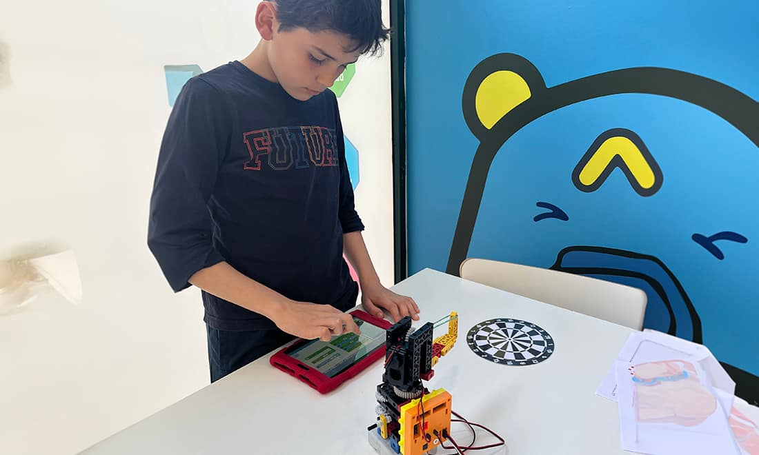 Robothink férias para crianças menino a programar robô no tablet