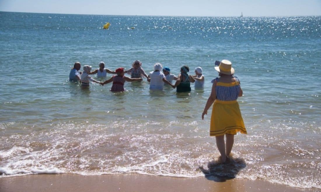 Câmara Municipal de Lagos Festa do Banho 29 grupo em roda no mar e mulher de costas a olhar para o mar