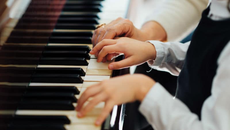 crianças a tocar piano