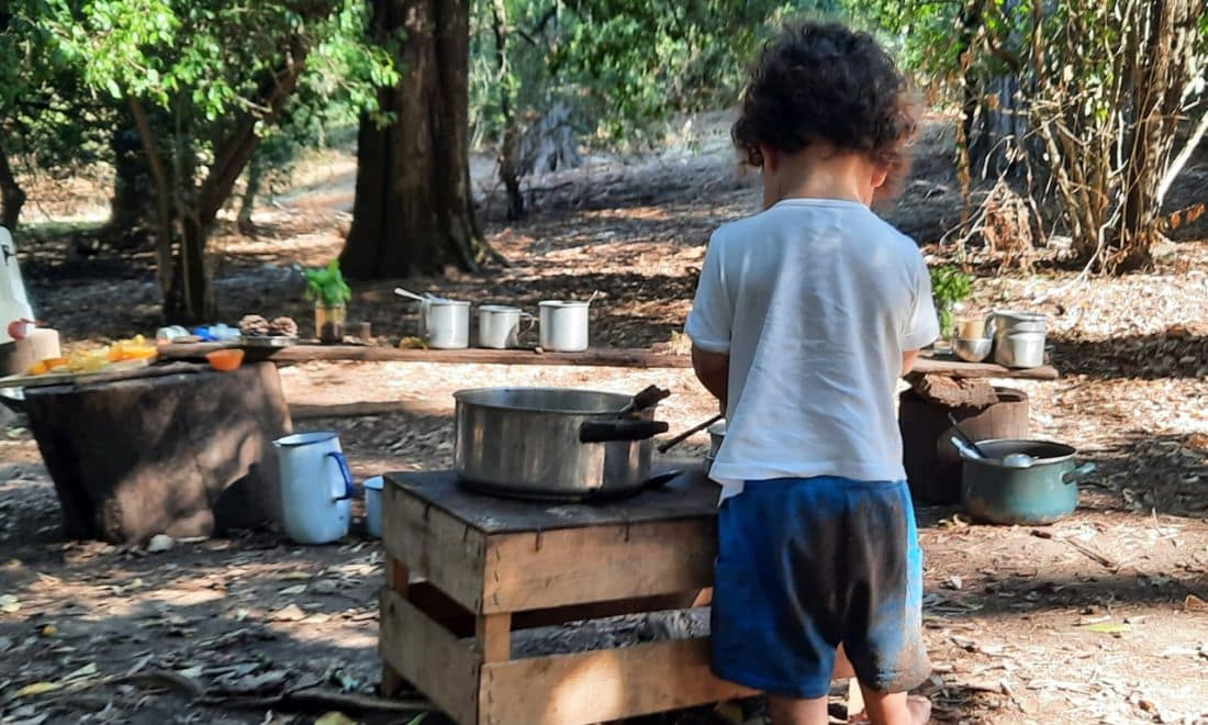 Escola Lá Fora atividades para crianças menino na natureza cozinhar com terra e folhas
