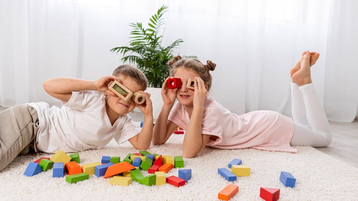 criancas-brincar-blocos-coloridos-no-chao-e-nos-olhos